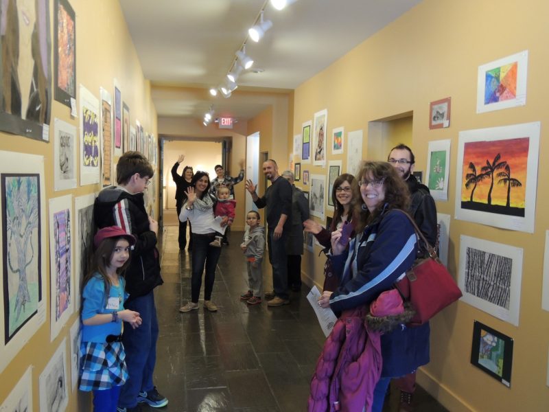 Crowd talking and waving in gallery