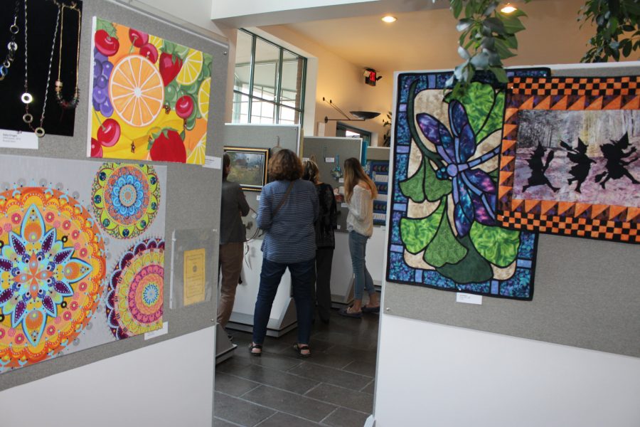 People looking at paintings glimpsed through a doorway