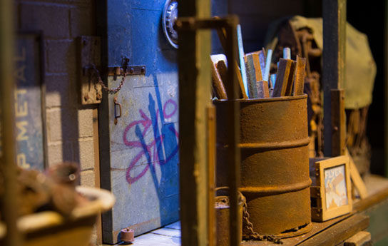 Watch For Trucks, 2013 Miniture Street scape, graffiti on the wall a steel drum with wood inside