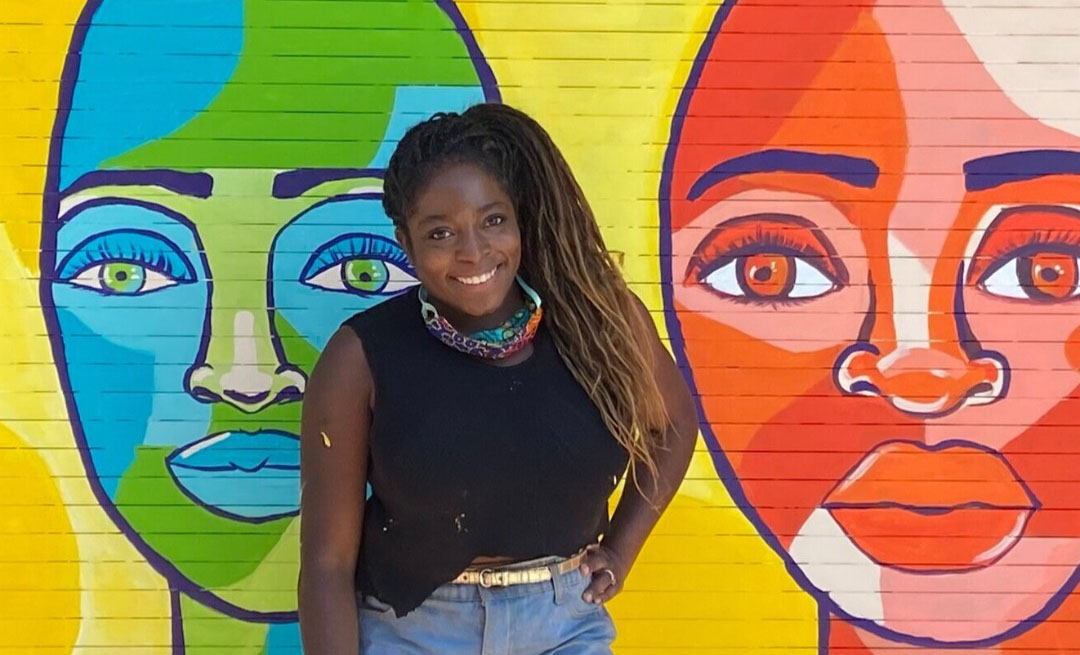 Artist Valerie Imparato stands against one of her murals featuring the faces of two women. Artist Valerie Imparato stands against one of her murals featuring the faces of two women.